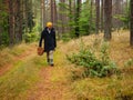 One person searching for a mushrooms in an autumn deep forest. mushroomer with a basket in a woods