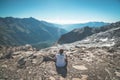 One person sitting on rocky terrain and watching a colorful sunrise high up in the Alps. Wide angle view from above with glowing m Royalty Free Stock Photo