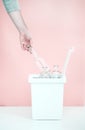 One person sorts recyclable materials on a pink background into a special bin