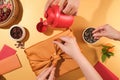 One person is wrapping a gift with a yellow silk cloth, one person is pouring tea, the other person is picking up sunflower seeds Royalty Free Stock Photo