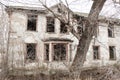 One photo of an old and terrible abandoned farmhouse, which eventually deteriorates, overgrown with old trees. Here lived an old m Royalty Free Stock Photo