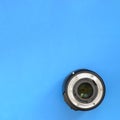 One photographic lense lie on a bright blue background. Space fo Royalty Free Stock Photo