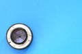One photographic lense lie on a bright blue background. Space fo Royalty Free Stock Photo