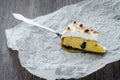 One piece of breton cake with plums and meringue on a wooden table