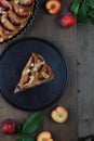 One piece of homemade plum pie on a plate . Rustic style