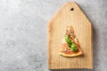 One piece of Italian pizza with tomatoes mushrooms bacon and cheese and basil leaves on wooden background cutting board Royalty Free Stock Photo