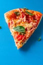 One piece of salami pizza on blue background. Royalty Free Stock Photo