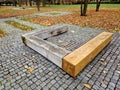 one piece of wood made prism park bench painted brown footsteps Royalty Free Stock Photo