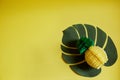 One pineapple made of paper on a yellow isolated background. Horizontal photo