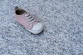 One pink baby shoe on a marble background. Concept of child abuse, kidnapping or pedophilia Royalty Free Stock Photo