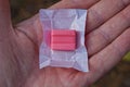 one pink chewing gum candie in open white packaging