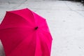 Pink colored, open umbrella on ground