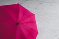 Pink colored, open umbrella lying open on ground