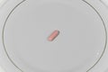 Pink pill in the plate Royalty Free Stock Photo