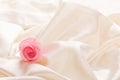 One pink rose laying in silk gift background Royalty Free Stock Photo