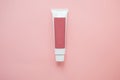 one pink tube cream of personal care cosmetics on a pink background, place for name