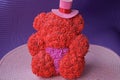 One plastic gift toy bear in a hat made of small red roses Royalty Free Stock Photo