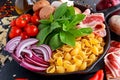 One pot pan pasta with bacon, chestnut mushrooms, cherry tomatoes, red onion, conchiglie and basil leaves Royalty Free Stock Photo