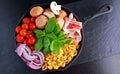 One pot pan pasta with bacon, chestnut mushrooms, cherry tomatoes, red onion, conchiglie and basil leaves Royalty Free Stock Photo