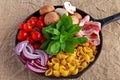 One pot pan pasta with bacon, chestnut mushrooms, cherry tomatoes, red onion, conchiglie and basil leaves Royalty Free Stock Photo