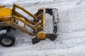 One powerful wheeled tractor removes a snow with scraper shovel blade snowplow on road after heavy snowfall at winter day, top