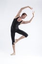 One Professional Male Ballet Dancer Young Man in Black Dance Tights Suit Posing in Ballanced Dance Pose in Studio