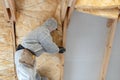 Professional worker in overalls working with rockwool insulation material