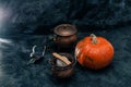 One pumpkin squash and copper or brass witch pots with candles black background Royalty Free Stock Photo