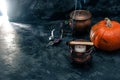 One pumpkin squash and copper or brass witch pots with candles  black textured background Royalty Free Stock Photo