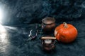 One pumpkin squash and copper or brass witch pots with candles black textured backgrounda Royalty Free Stock Photo