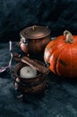 One pumpkin squash and copper or brass witch pots with candles close. uo Royalty Free Stock Photo