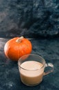 One pumpkin squash and a latte coffee made with with plant based oat soya or almond milk  with blank notepad notebook at the table Royalty Free Stock Photo