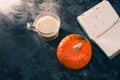 One pumpkin squash and a latte coffee made with with plant based oat soya or almond milk  with blank notepad notebook at the table Royalty Free Stock Photo