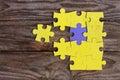 One purple puzzle and many yellow puzzles Royalty Free Stock Photo