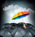 One rainbow umbrella standing out on a grey background. Royalty Free Stock Photo