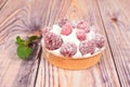 One raspberry tartlet on a wooden table