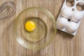 One raw chicken yolk and whites in glass bowl on wooden table Royalty Free Stock Photo