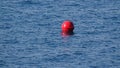 One red buoy on waves in blue sea water. Backgrounds and pictures. Royalty Free Stock Photo