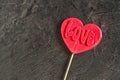 One red candy lollipop heart shape with `love` inscription