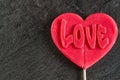 One red candy lollipop heart shape with `love` inscription