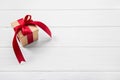 One red christmas present on white wooden background with a big