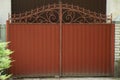 One red closed iron gate with a wrought iron pattern