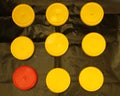 One red and eight yellow plastic round lid for jars on a black background