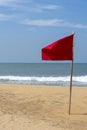 One red flag on the beach with a very calm ocean Royalty Free Stock Photo