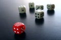 One Red game dice in front of five white game dice Royalty Free Stock Photo