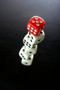 One Red game dice on top of stacked five white game dice Royalty Free Stock Photo