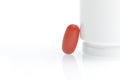 One red medical pill near white container Royalty Free Stock Photo