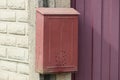 One red metal mailbox hanging on a white brick wall Royalty Free Stock Photo