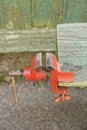 One red old iron machine clamp on a gray wooden table Royalty Free Stock Photo