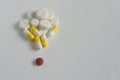 One red pill with many white and yellow  pills on white background. copy space Royalty Free Stock Photo